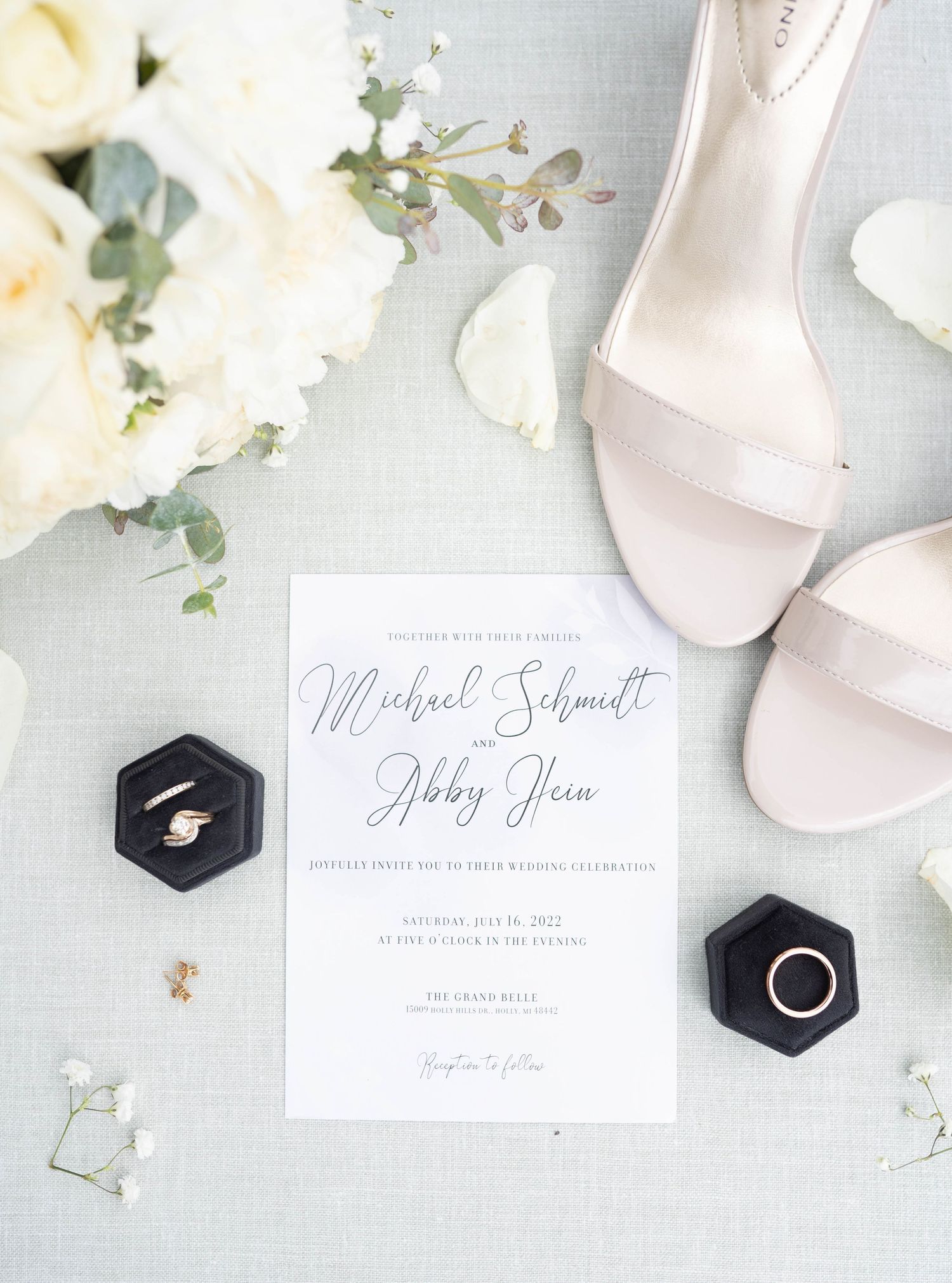 A wedding invitation with elegant calligraphy and decorative elements is displayed on a soft, light background.