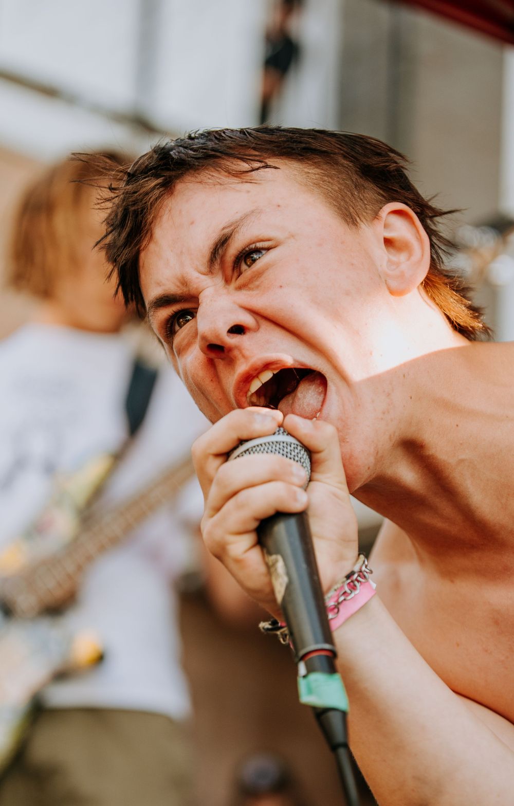 Passionate vocalist singing intensely into a microphone during a live performance.
