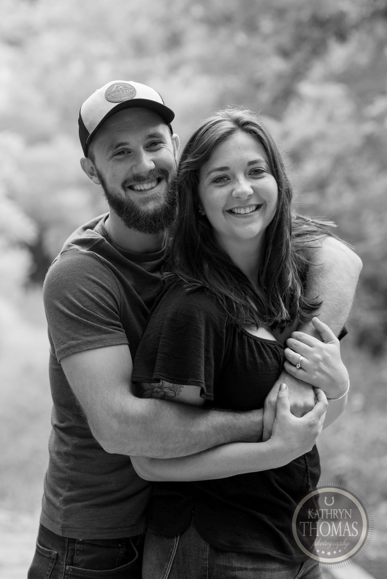 A black and white portrait of a happy couple embracing outdoors.