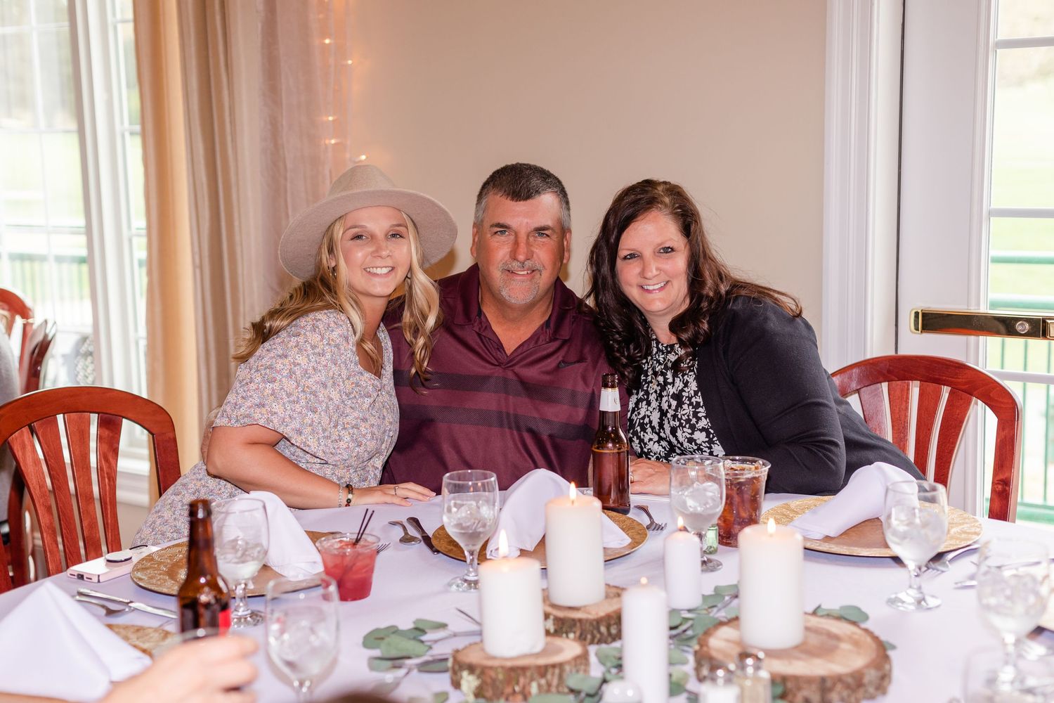 Wedding reception guests enjoying dinner at elegantly decorated tables with white linens.