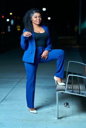 Stylish blue business suit paired with white heels in an evening outdoor photoshoot.