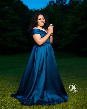 Elegant blue satin evening gown captured in a dramatic outdoor portrait session.