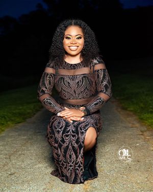 Intricate brown and beige lace evening dress with sheer details photographed at dusk.