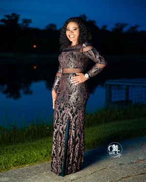 Elegant black lace gown with sheer details photographed against a twilight lake backdrop.