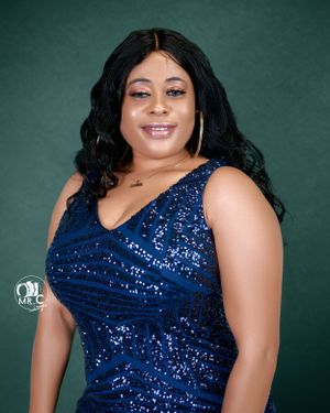 Woman in navy sequined dress poses against green background for formal portrait.