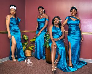 Four women in matching blue satin gowns pose together in formal portrait.