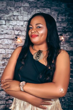 Studio portrait against brick wall background featuring statement necklace and elegant makeup.