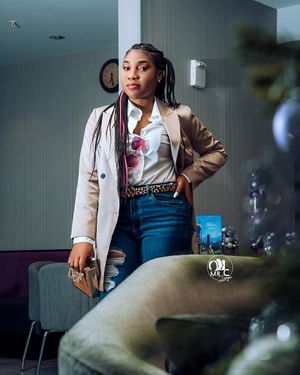 Fashion portrait in beige blazer and graphic tee with modern interior setting.