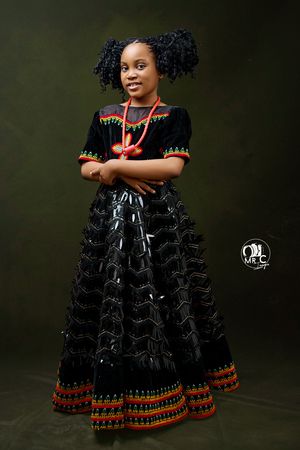 Beautiful portrait of a traditional dress featuring black tulle and orange tribal embroidery details.