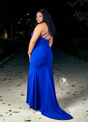 Elegant royal blue mermaid gown shown from back view on outdoor path with fallen leaves.