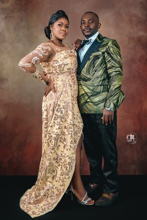 Elegant couple in formal wear featuring gold sequined gown and green patterned suit.