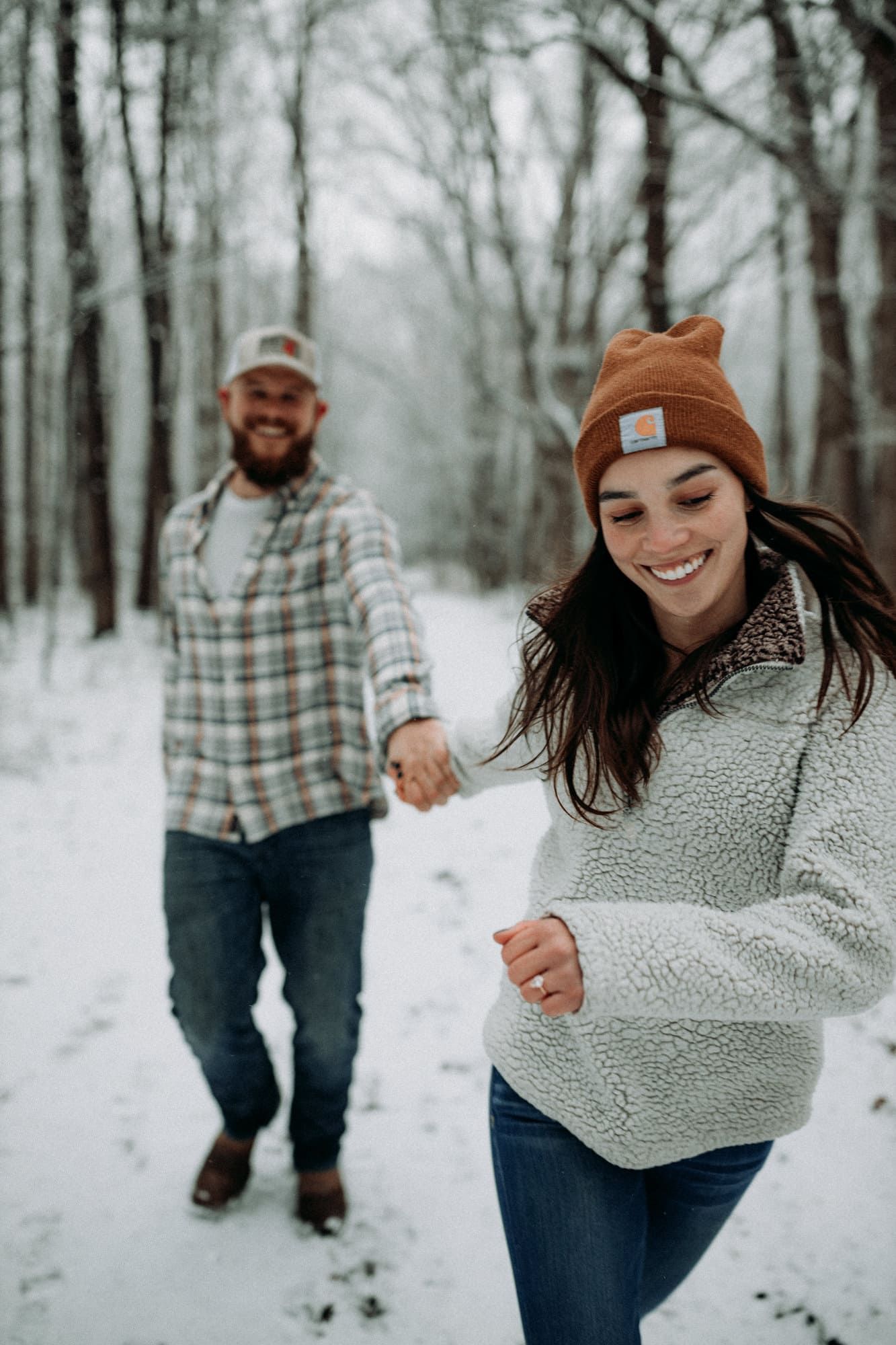 engaged-couple-running-snow