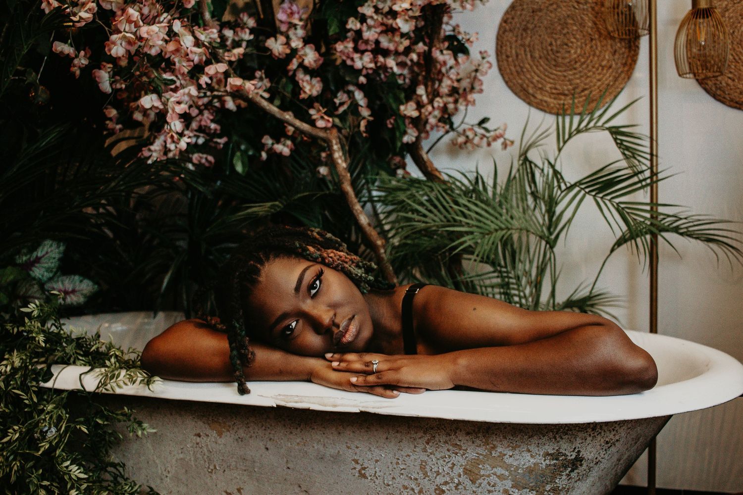Artistic bathtub portrait series with cherry blossoms and natural lighting.