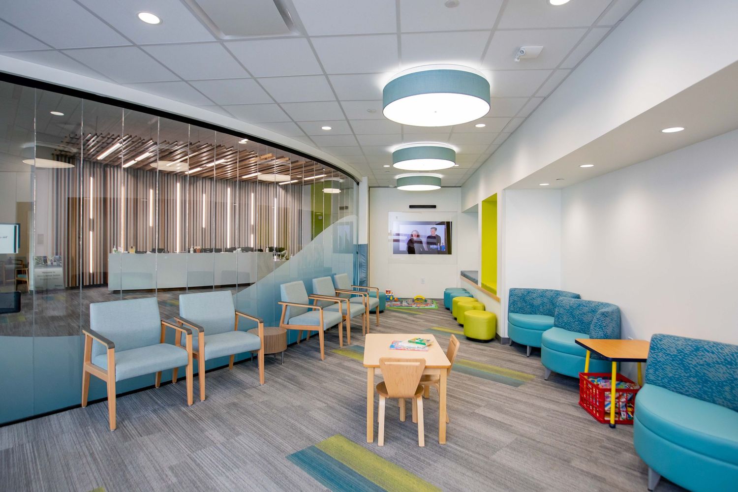 Modern office lounge area with blue furniture and contemporary lighting fixtures.