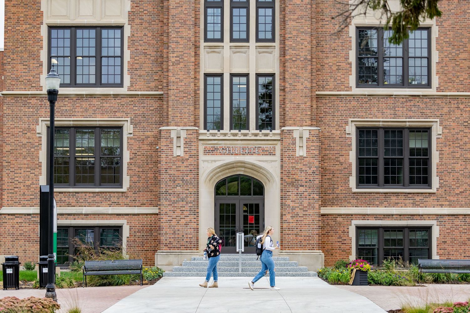 Exterior view of a traditional brick university building with large windows and architectural details.