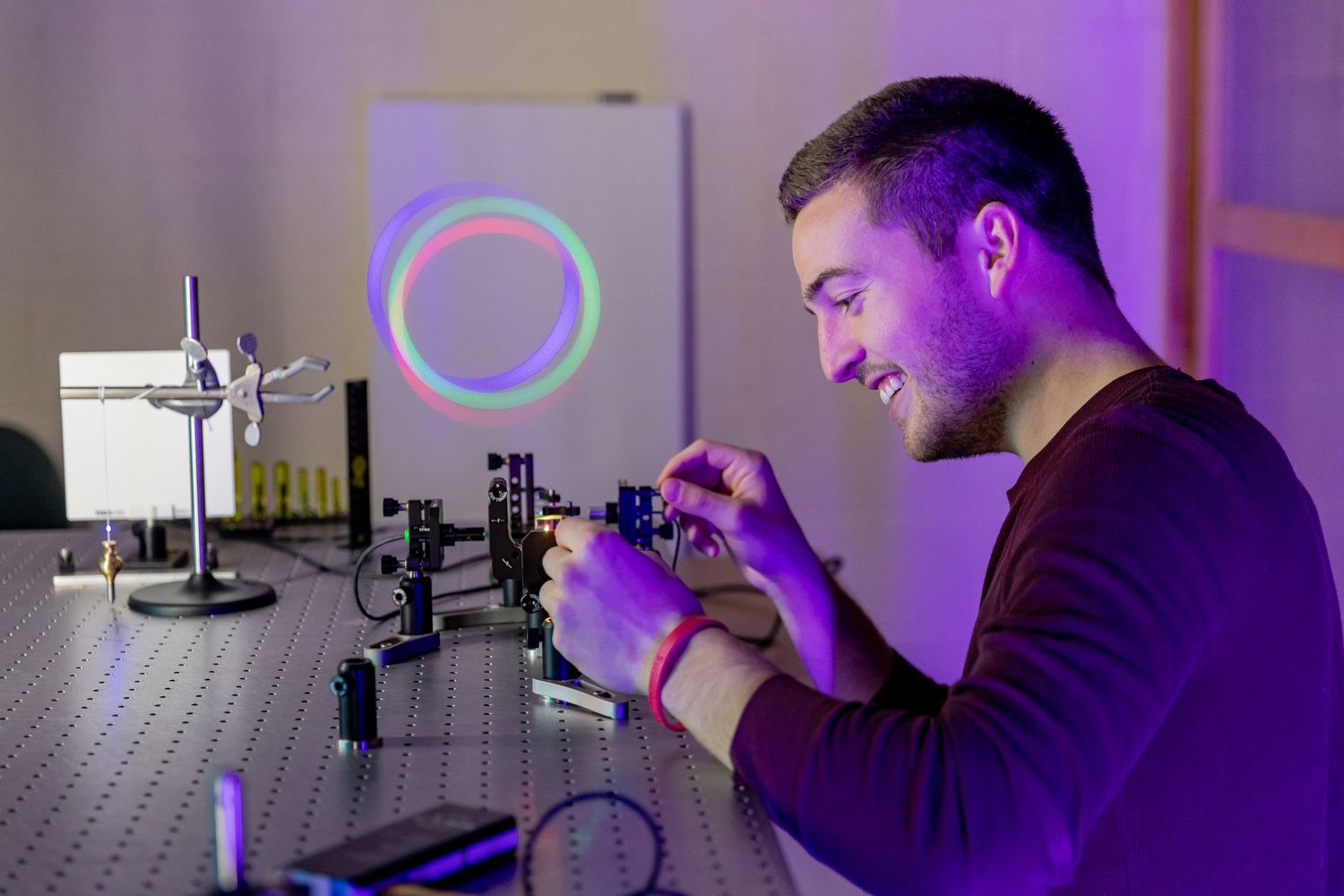 Scientists working with laboratory equipment under purple ambient lighting.