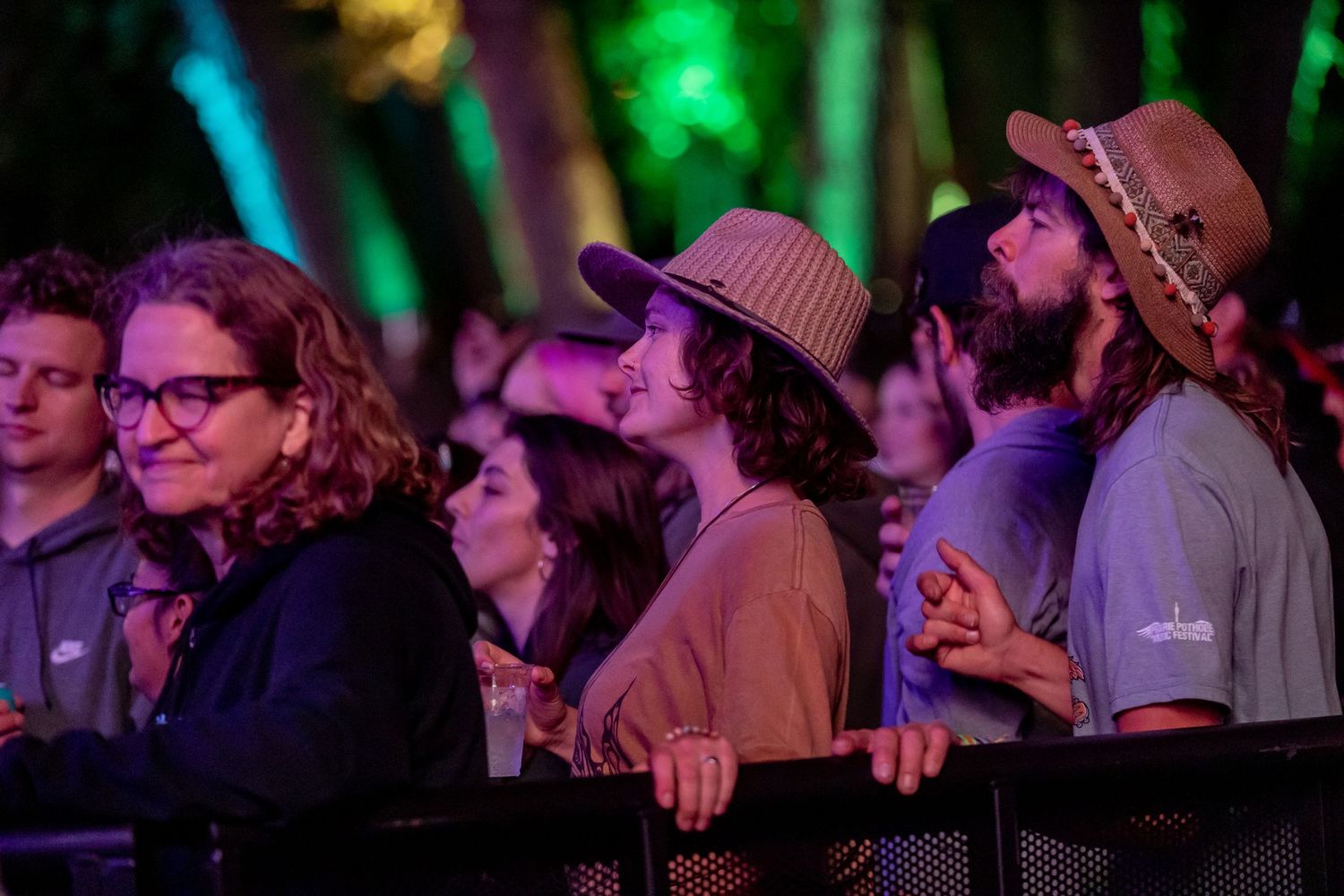 Concert crowd watching a performance under colorful stage lighting.