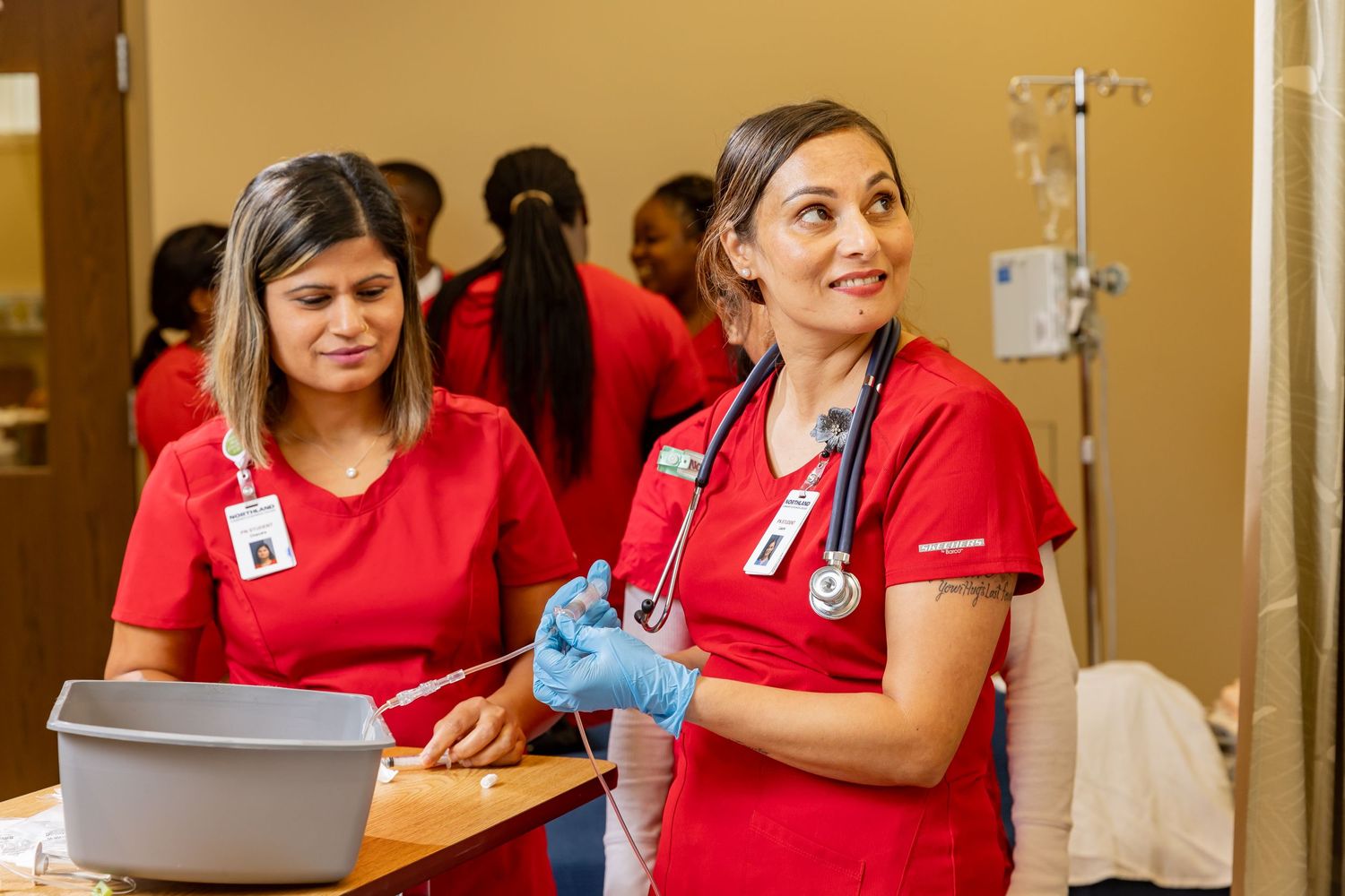 Medical professionals in red uniforms working together in a healthcare setting.