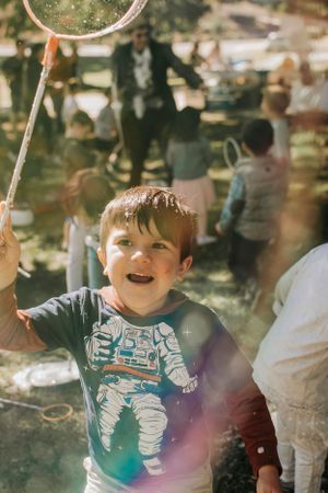 Child playing with bubbles outdoors on a sunny afternoon.