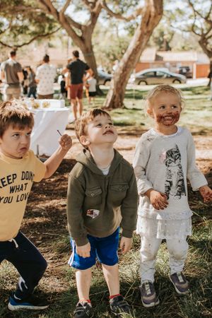 Three children playing together at an outdoor party.