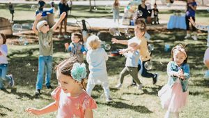 Children running and playing during an outdoor party celebration.