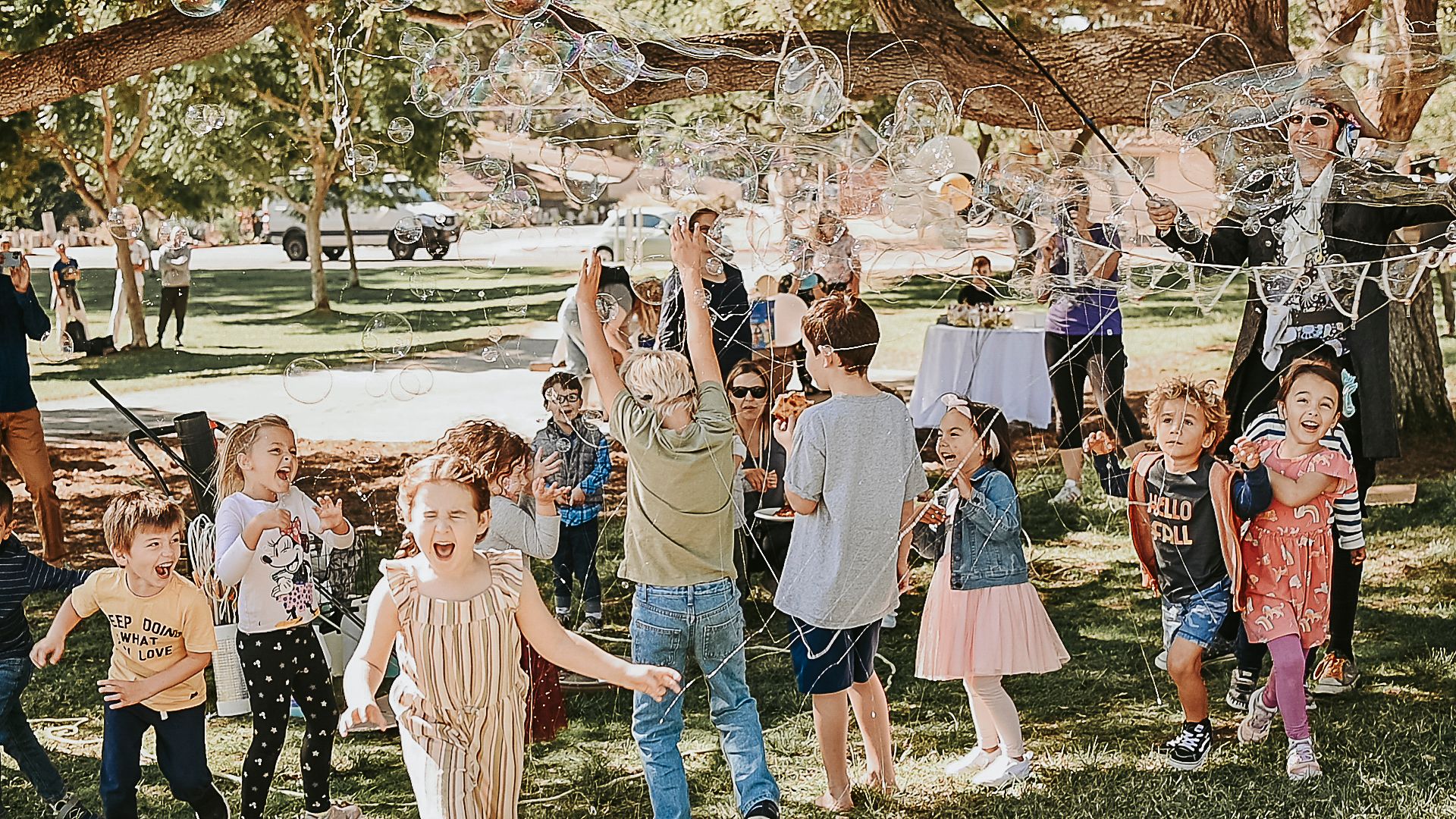 Outdoor safari-themed party setup with guests gathered in a natural setting.