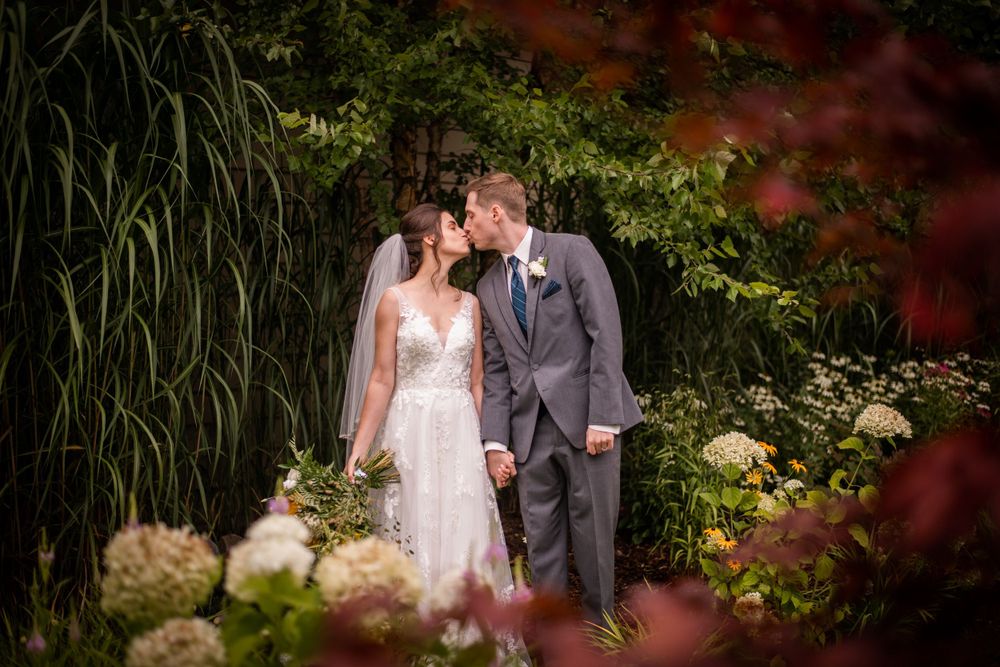 Bride and groom kissing in the garden at Stratford Country Club wedding