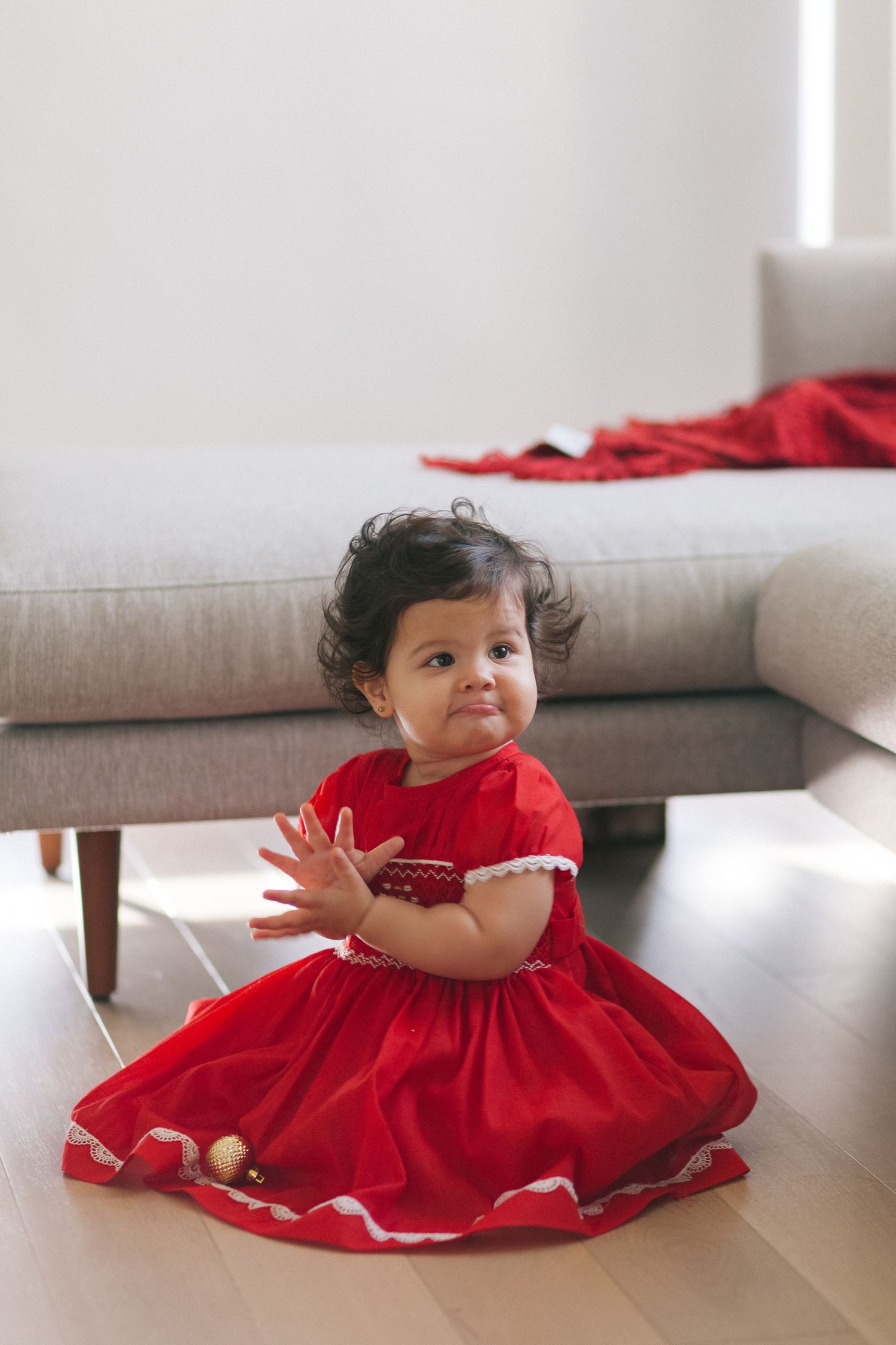 Candid of girl in red dress during holiday family session, photographed by Paula Brearley NYC family photographer