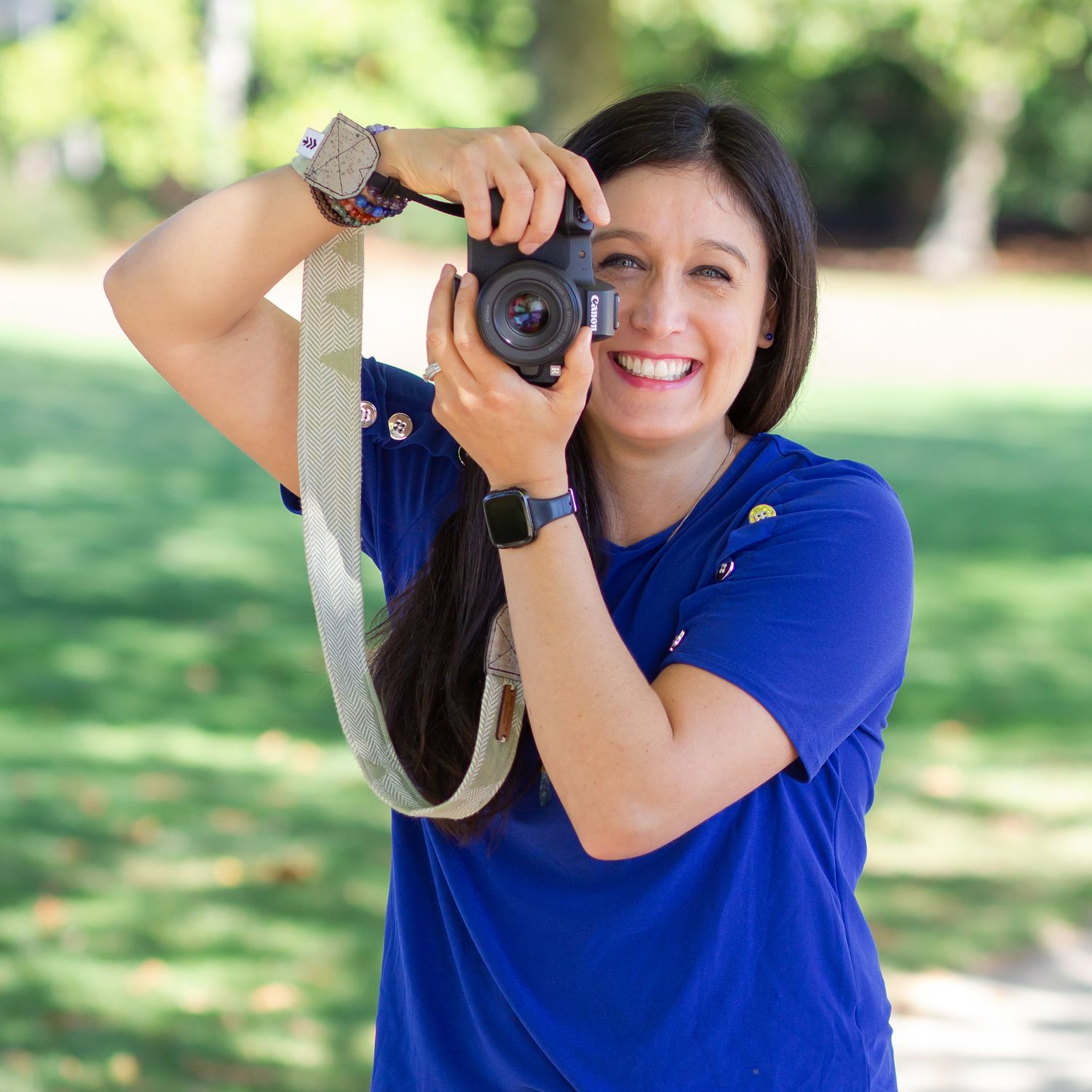 Female personal branding and headshot photographer in Seattle, Tacoma, WA holding camera smiling