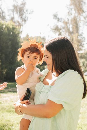 Outdoor family moment captured in warm sunlight with mint green dress and lion headpiece.