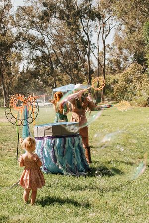 A bubble station with blue decorations set up in a grassy outdoor area.