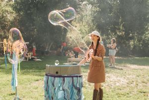 Giant bubble-making station with turquoise decorations in a sunny outdoor setting.