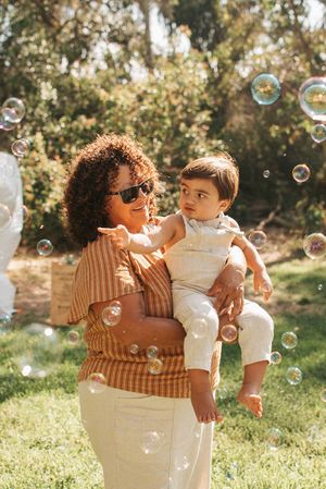 A sunny afternoon moment captured with soap bubbles floating around during an outdoor celebration.