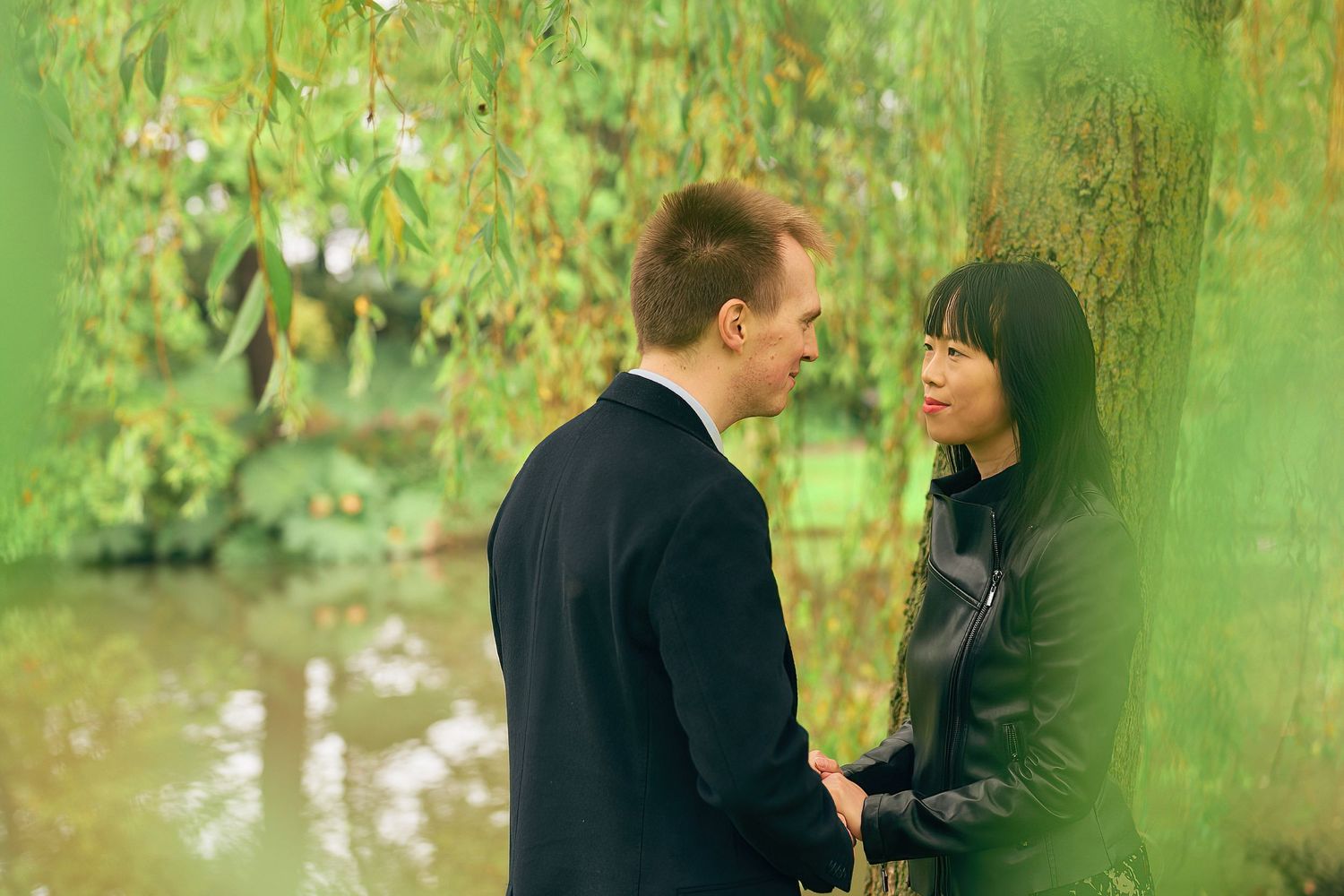 Romantic outdoor couple photoshoot in a lush green garden setting.