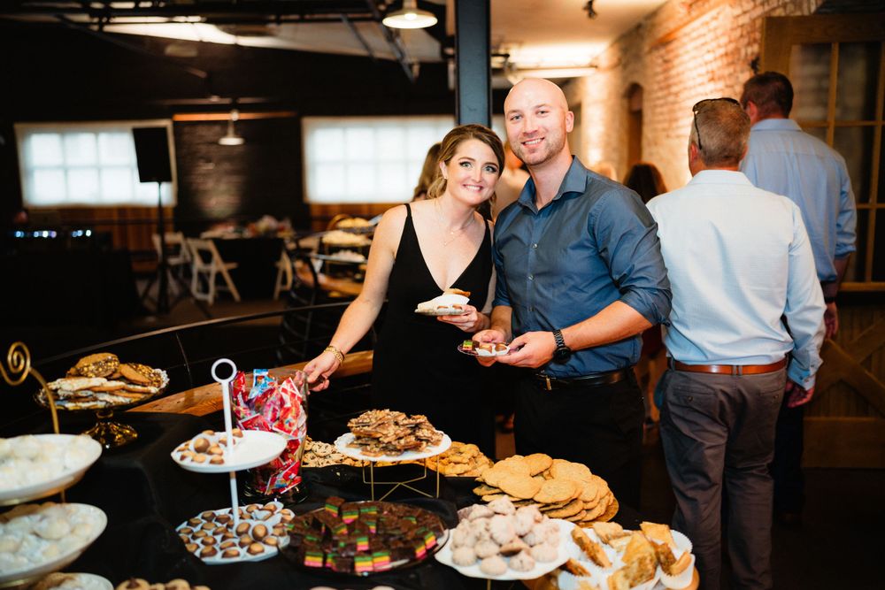 Dessert table with treats and sweets at wedding reception in rustic industrial venue.