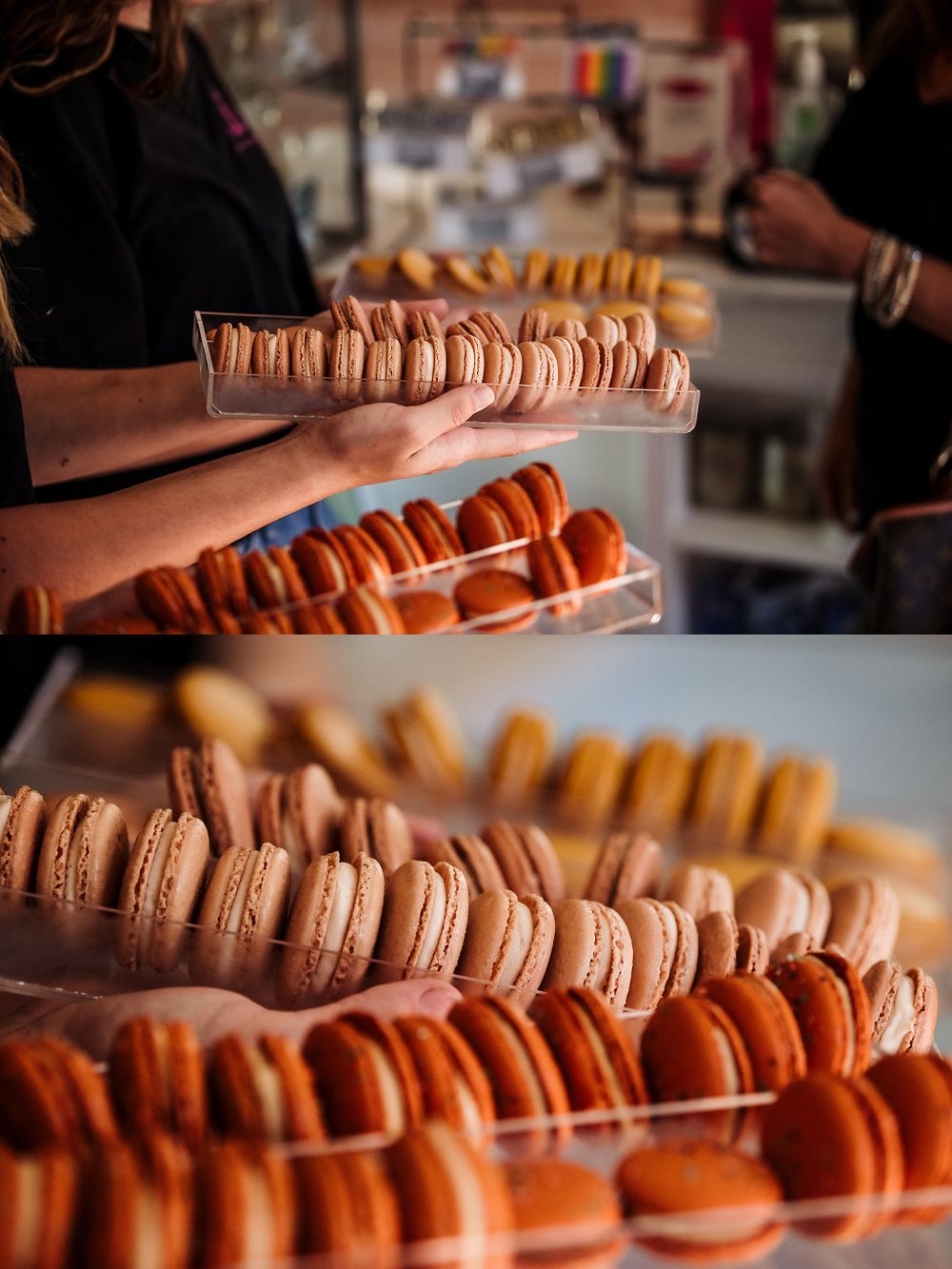 Rows of colorful macarons displayed on trays in varying shades of brown and orange.