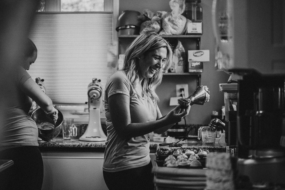 Black and white photo of someone working in a bakery kitchen with natural lighting.