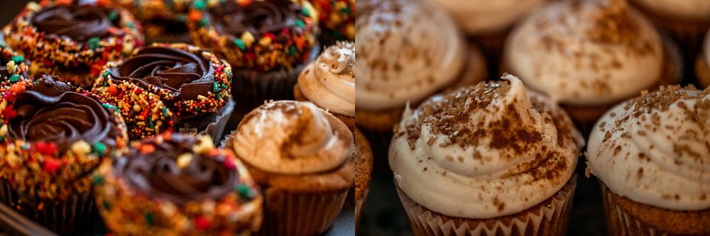 Close-up of decorated cupcakes with ornate frosting and sprinkles on display.