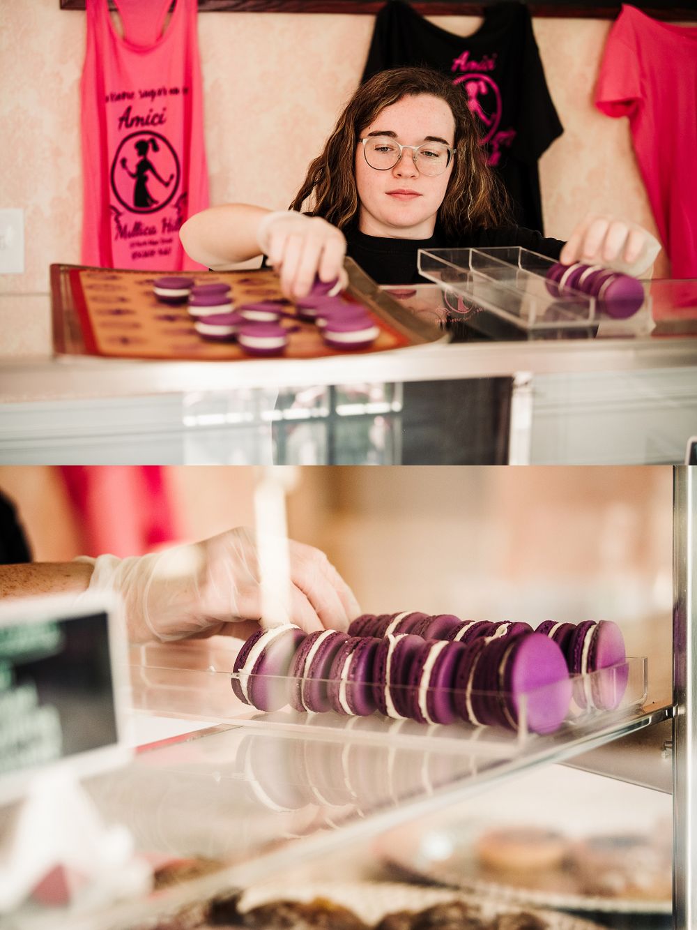 Colorful macarons displayed in a bakery case with pink decor in the background.