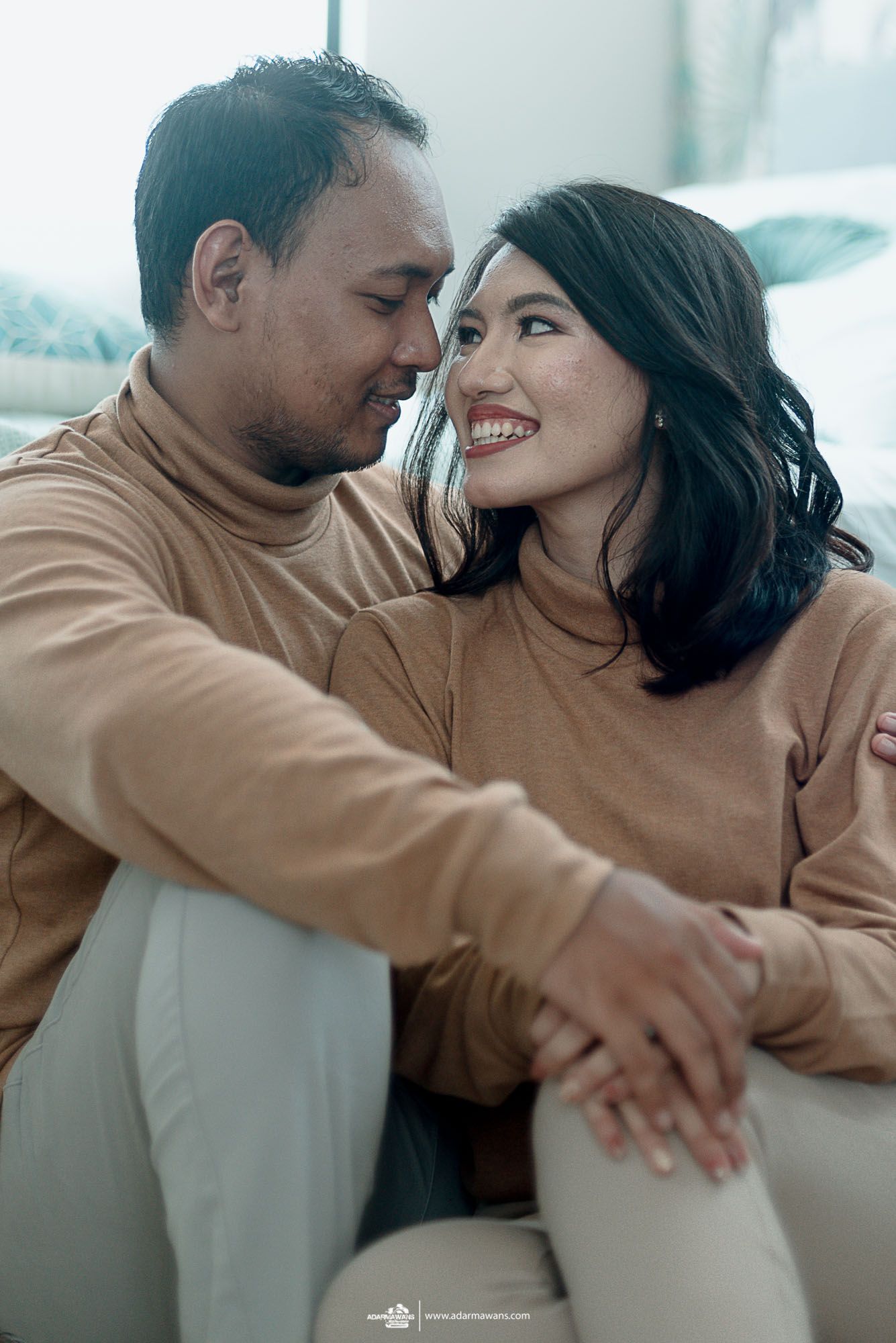 Couple in matching turtlenecks sharing intimate moment while sitting together.