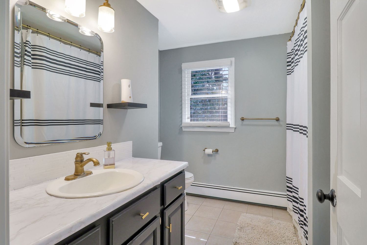 Contemporary bathroom featuring white vanity, modern fixtures, and sleek grey walls.