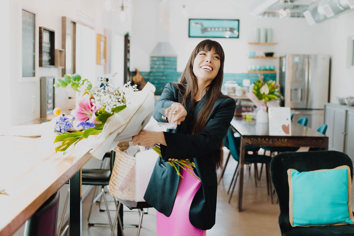 A bright interior scene with floral arrangements and turquoise coastal decor.