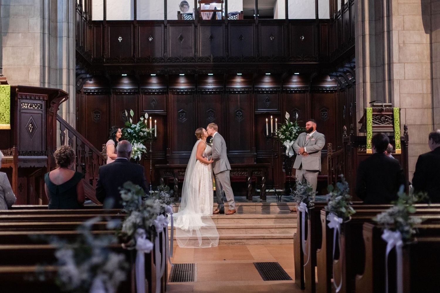 Traditional church interior with wooden architectural details and stained glass windows.