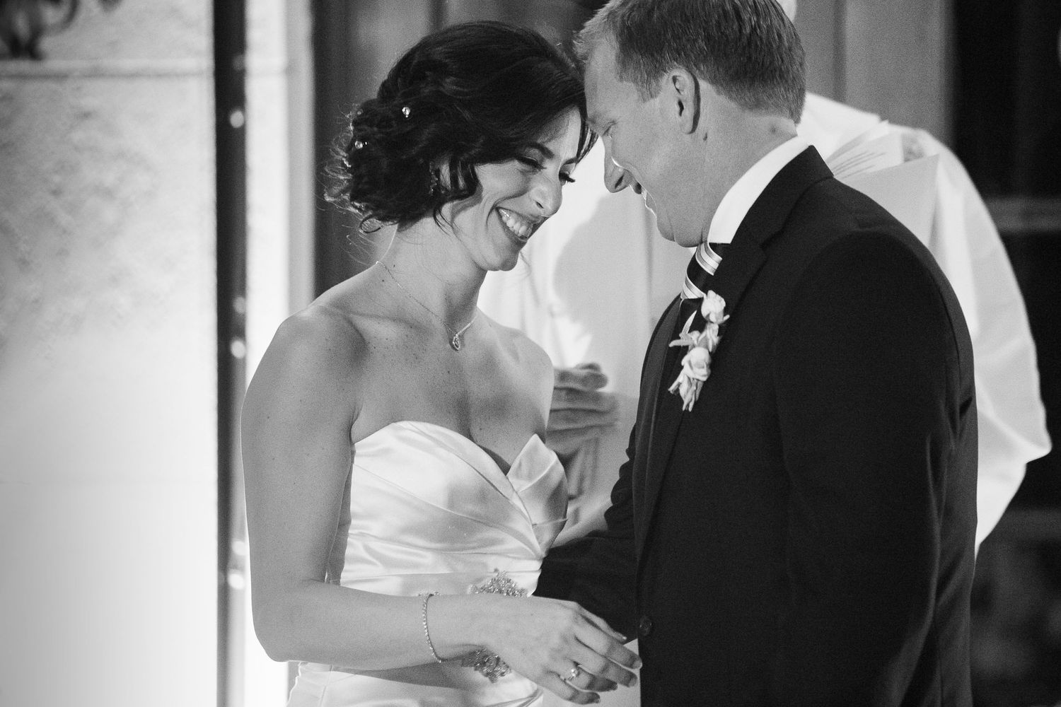 Intimate black and white moment between newlyweds during wedding ceremony.