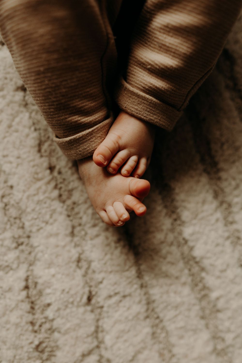 Close-up of tiny baby feet resting on textured fabric.