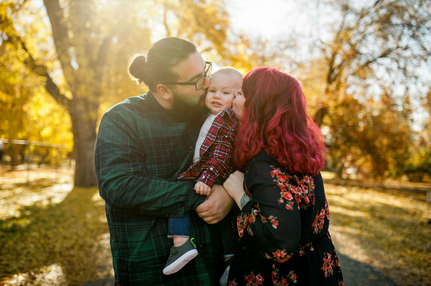 A tender family moment captured in golden autumn sunlight outdoors.