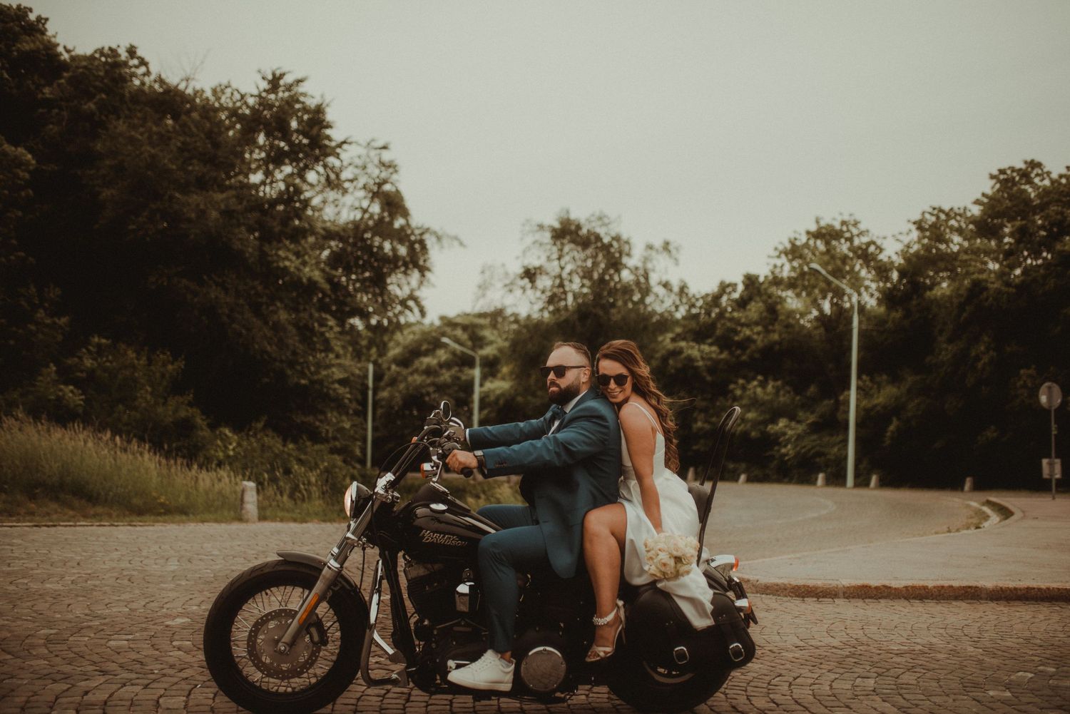 Bride and groom riding Harley Davidson at Khalenberg in Vienna, Austria.