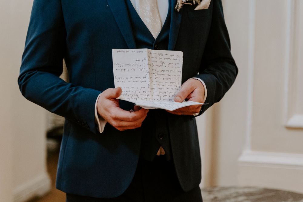 a close up of the grooms speech in his hand.