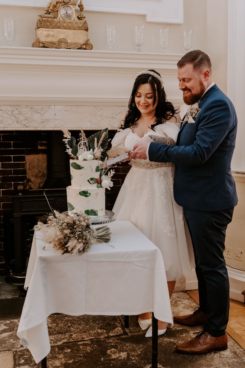 bride and groom cutting their 3 tier cake.