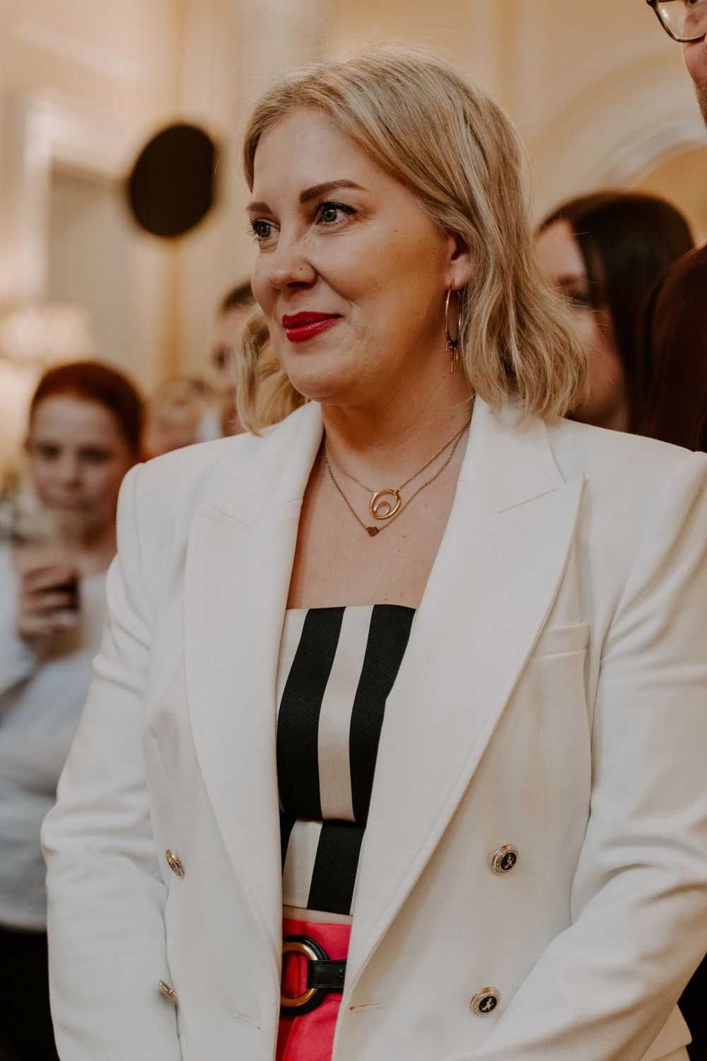 a wedding guest listening to the speeches and smiling.